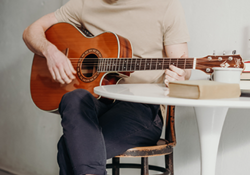 man musiceert moeiteloos op zijn gitaar